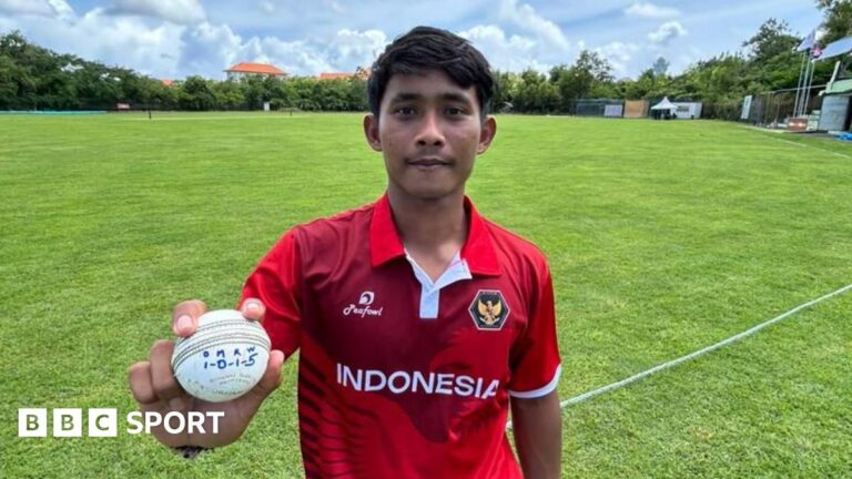 Gede Priandana holding a ball with his bowling figures of 5-1 written on
