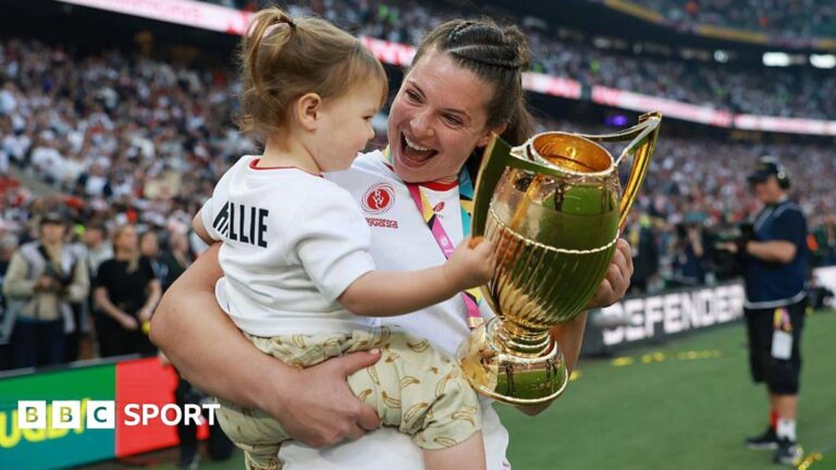 Abbie Ward celebrates winning the Women's Rugby World Cup last year as she holds the trophy and young daughter Hallie
