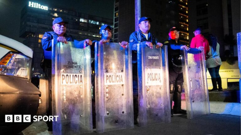A row of riot police with shields