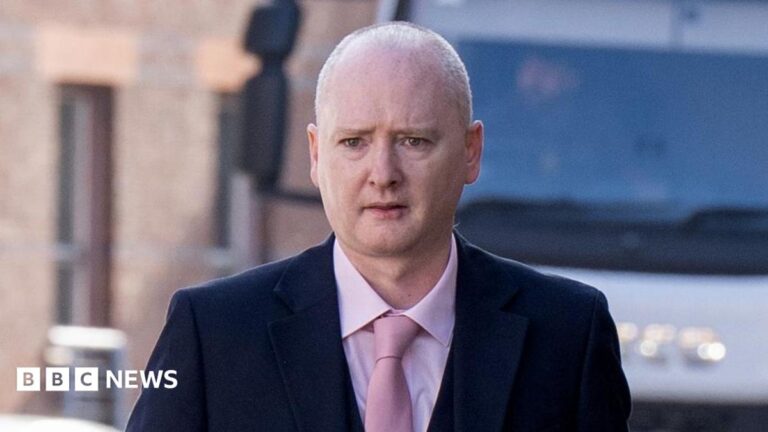 Graeme Dott arriving at the High Court in Glasgow. He is wearing a dark suit over a pink shirt witha pink tie.