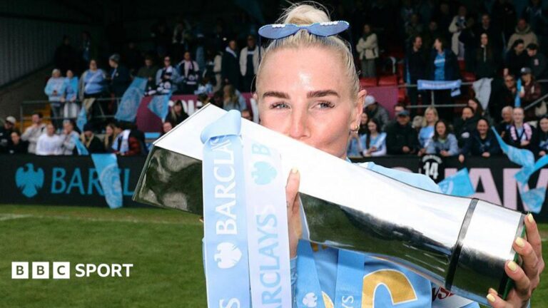 Alex Greenwood lifting and kissing the WSL trophy last season