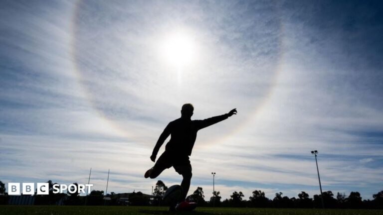 Heat risk in sport: Are chances of death and serious illness growing with extreme temperatures? A silhouetted rugby player strikes the ball off a tee during a training session, with the sun glaring down from behind him