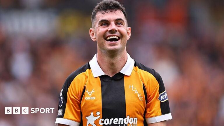 John Egan: Republic of Ireland’s defender’s late career resurgence back to Premier League John Egan, in Hull's black-and-amber-striped kit, smiles while looking at the crowd during a Premier League match