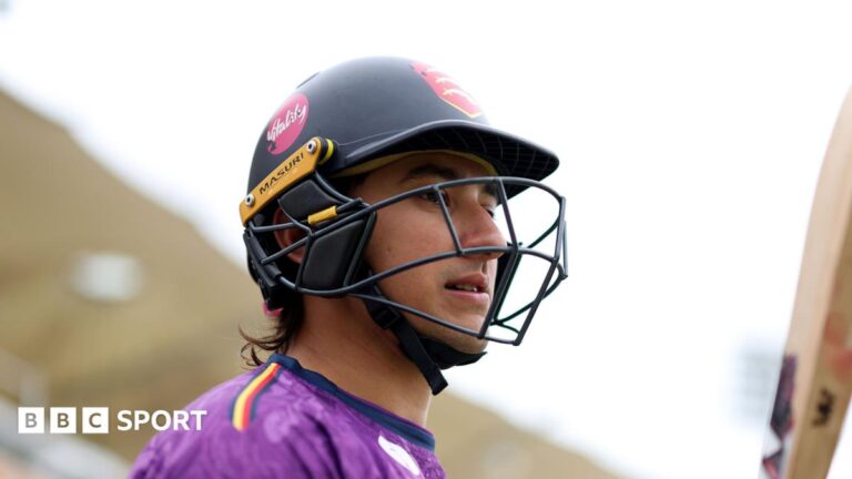Robin Das: Essex cricketer charged with two counts of rape Robin Das wearing a black cricket helmet, carrying a cricket bat and wearing a purple top